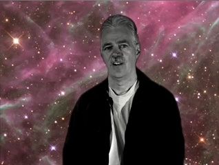 Black and white photo of a man with short hair, with a representation of the the pink Milky Way in the background