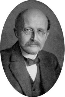 Photo en médaillon en noir et blanc d'un homme portant des lunettes rondes, une moustache et un noeud papillon