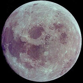 Photographie de la pleine lune aux tons rouges et bleutés sur un fond noir