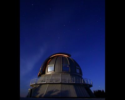 Night photo of a metal dome under a star-filled sky